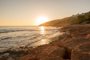 Çok Bulutlu bir gün batımı sakin denizde