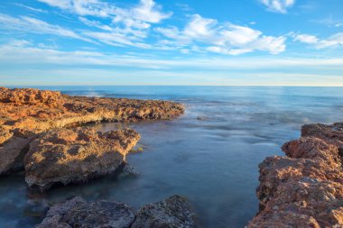 Çok Bulutlu bir gün batımı sakin denizde