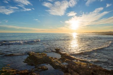 Çok Bulutlu bir gün batımı sakin denizde