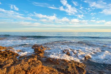 Çok Bulutlu bir gün batımı sakin denizde