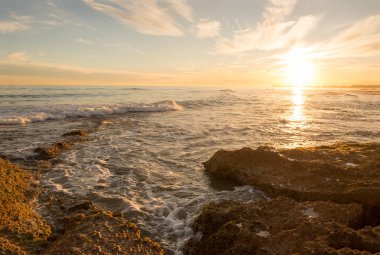 Çok Bulutlu bir gün batımı sakin denizde