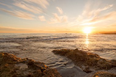 Çok Bulutlu bir gün batımı sakin denizde