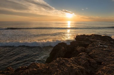 Çok Bulutlu bir gün batımı sakin denizde