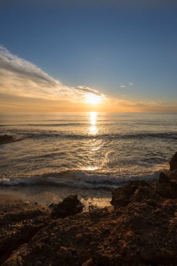 Çok Bulutlu bir gün batımı sakin denizde
