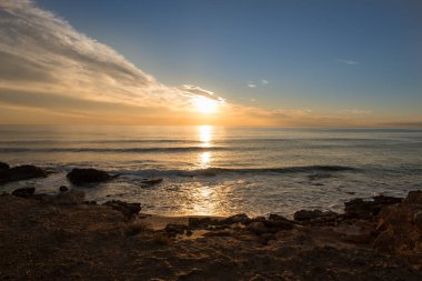Çok Bulutlu bir gün batımı sakin denizde