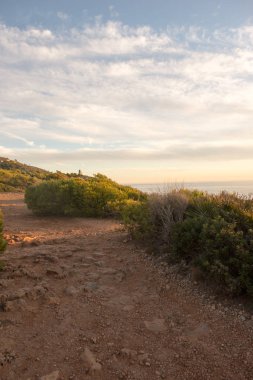 Çok Bulutlu bir gün batımı sakin denizde