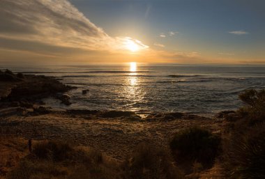Çok Bulutlu bir gün batımı sakin denizde