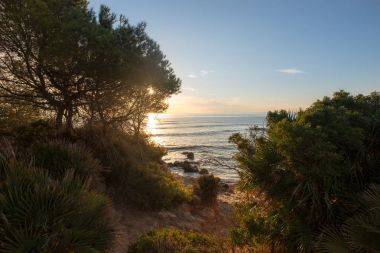 Çok Bulutlu bir gün batımı sakin denizde