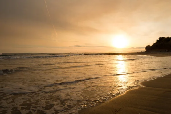 Die ruhige See in einem sehr bewölkten Sonnenuntergang — Stockfoto