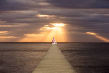 Arka planda bir yelkenli ile ahşap yaya köprüsü