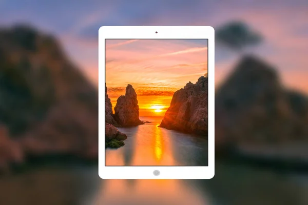 Een tablet met de zee op de achtergrond — Stockfoto