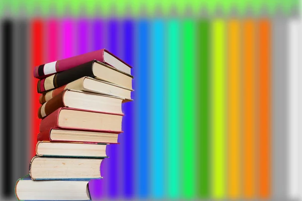Stacked books with a background of colored pencils — Stock Photo, Image