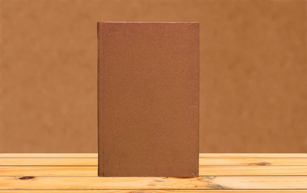 Livro em uma mesa de madeira com fundo laranja — Fotografia de Stock