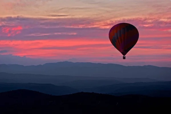 Balão aerostático com um pôr-do-sol vermelho no fundo — Fotografia de Stock