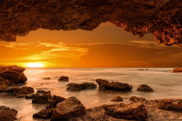 Salida del sol en el mar desde una cueva — Foto de Stock