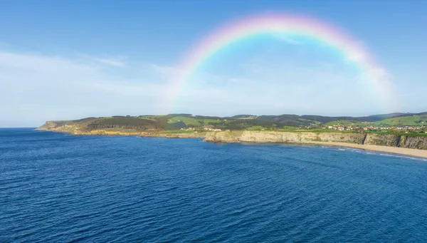 Mounts met de regenboog op een strand in Cantabrië — Stockfoto