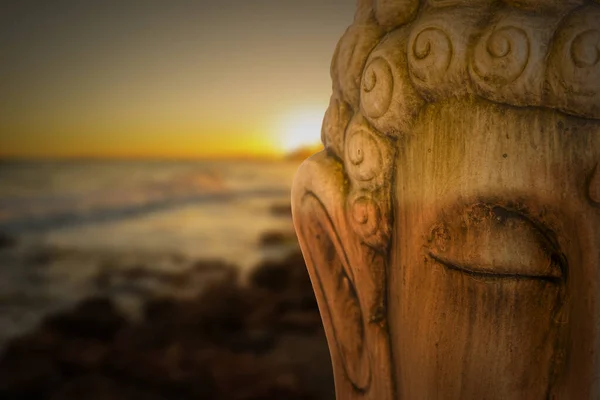 Η φιγούρα του Βούδα διαλογίζεται με μια ανατολή στην παραλία — Φωτογραφία Αρχείου