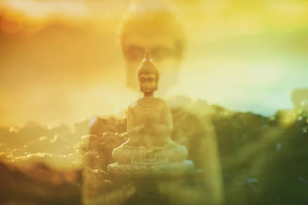 Doble exposición de una figura de Buda meditando sobre la roca — Foto de Stock
