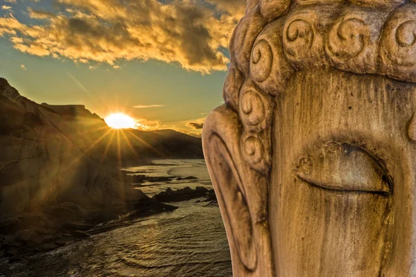 Figure of a Buddha with the sea at sunset background — Stock Photo, Image