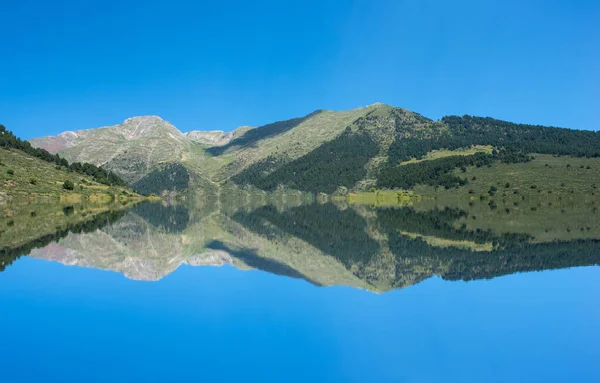 Un lago en la montaña bajo el cielo azul — Foto de Stock