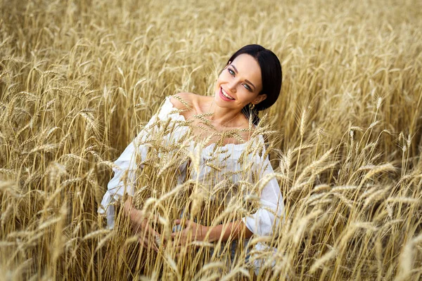 Buğday tarlasında beyaz elbiseli güzel bir kadın portresi.