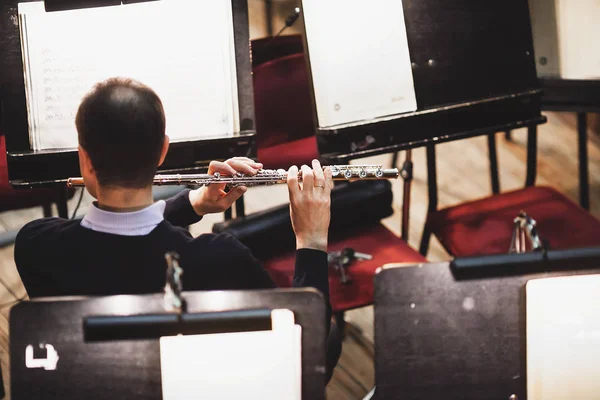 O homem a tocar flauta num poço de orquestra. Orquestra de som de perto . — Fotografia de Stock