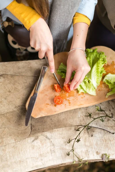 the girl cuts cherry tomatoes.