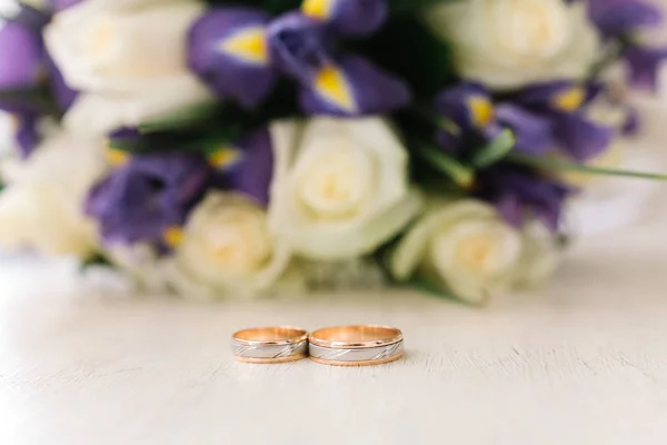 Anillos de oro sobre el fondo de un ramo de bodas — Foto de Stock