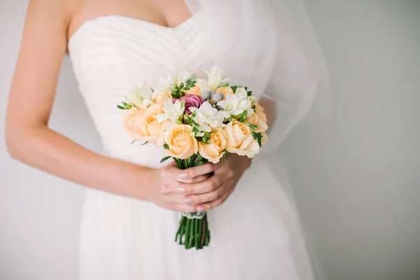 Hält die Braut einen wunderschönen Brautstrauß in der Hand. schöne Frau im Brautkleid. — Stockfoto