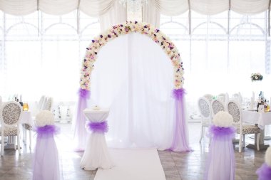 çiçek kemer beyaz bir arka planda bir ışık düğün dekorasyonu ile restoranda bir düğün töreni için taze renk arasından.