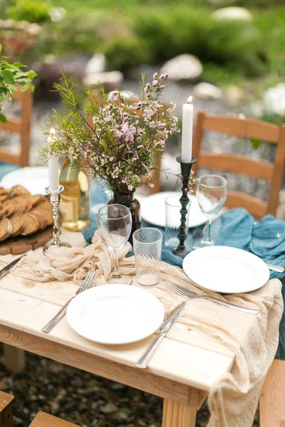 Almoço festivo de primavera um ao ar livre, decoração de casamento de uma mesa, layout de mesa, o pão de redução fresco, buquê de flores selvagens em um vaso . — Fotografia de Stock