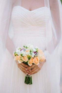 Çiçekler buket gül dan el dışında tutan bir beyaz gelinlik güzel kadın. Beyaz bir arka plan üzerinde düğün gelin buketi.