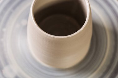 Kupa tekerlek yakın çekim bir bükülmüş potters kil oluşturma. Makro. Clay metni boş yeri olan bir bükülmüş potters tekerlek üzerinde bulanık kupa.