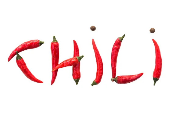 Het woord Chili van verse rode chilipepers en gedroogde zwarte paprika's op een witte achtergrond, geïsoleerd. concept heet kruid voor de menselijke voeding. plat lag. — Stockfoto