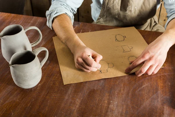 potter seramik ürün kağıt üzerinde çizimler yapar. küçük işletme, el işi çalışmaları kavramı. yatay metin için boş yer resimle.