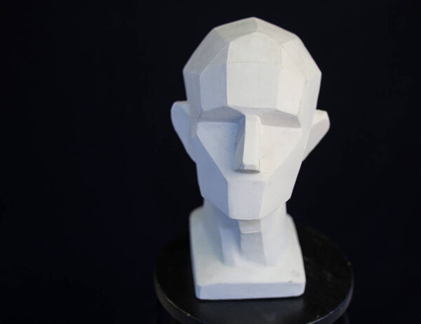 plaster bust of the person on a black background in style a cubism.