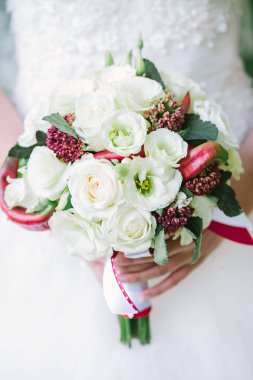 Çiçekler buket gül dan el dışında tutan bir beyaz gelinlik güzel kadın. Beyaz bir arka plan üzerinde düğün gelin buketi.