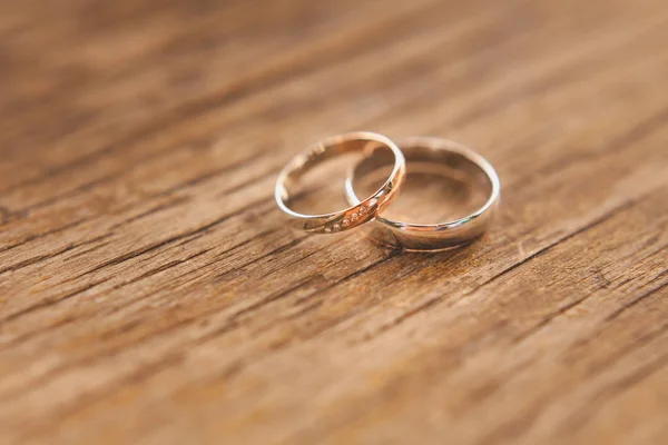 Dois anéis de casamento de ouro em um fundo de madeira, macro, DOF . — Fotografia de Stock