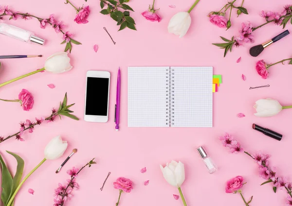 Girly, güzellik blog, Bahar, kavram. Kadınsı bloggerworkspace dizüstü bilgisayar, telefon, parfüm, sakura, gül, Lale çiçek ve Bayan aksesuarları pembe bir arka plan üzerinde. düz yatıyordu, en iyi görünümü