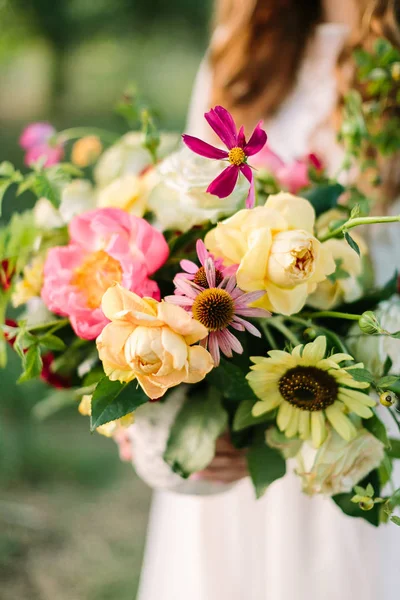 Boeket, mensen, bloem vakantie, cadeau en florale regeling concept - close up van mooie zomerse boeket in handen van de jonge vrouw, met vaas op de achtergrond van de natuur, decoratie kunstwerk, verticaal. — Stockfoto