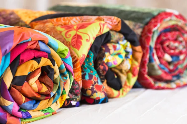 Drei farbige Patchwork-Quilts in Nahaufnahme verdreht. farbenfrohe, zusammengefaltete Decken als Hintergrund. Handgemacht. dof. — Stockfoto