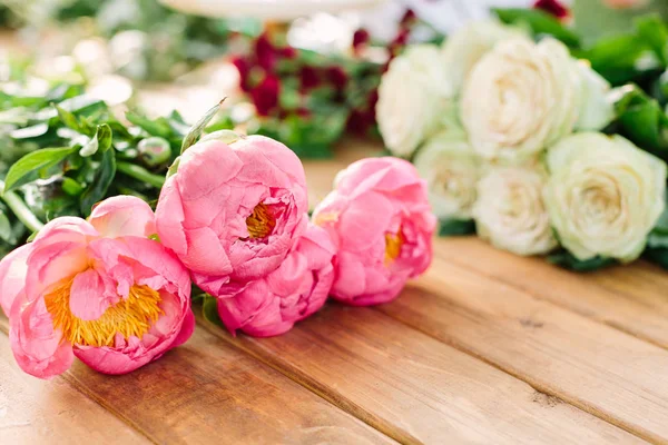 Vakantie bloemen en bloemen regeling concept - close-up op de mooie bloemen van roze pioen en witte rozen, versheid van natuurlijke planten, boeketten op houten tafel, selectieve aandacht. — Stockfoto