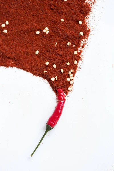 red hot chili peppers, popular spices concept - artistic idea of red hot pepper pod turns into a picture from powder of dry pepper, embodiment of abstract artist brush on white background, vertical.