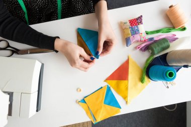 dikiş ve kapitone genç bir kadın - atölye dikişli konuları pins, yastık ile renkli kumaş parçalarını bir terzi kadına yakın çekim elleri çalışmak.