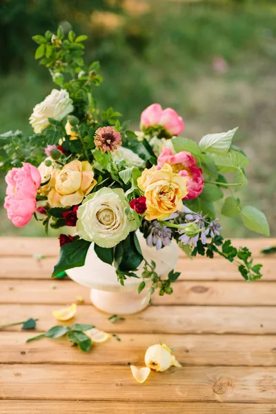 Csokor, virág, ajándék nyaralás és virág elrendezése koncepció - fehér váza, gyönyörű sárga és a fehér rózsák, rózsaszín bájos küldönc, szegfű, lő a wild rose, fából készült tábla, zöld háttér. — Stock Fotó