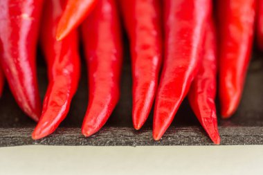 Red hot chili peppers, popüler baharatlar kavramı - makro keskin uçları kırmızı pul biber, taze temiz sulu bakla karanlık paket deposu, üstten görünüm, düz lay üzerinde.