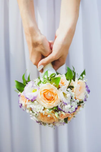 Mulher bonita em um vestido de noiva branco segurando um buquê de flores de rosa na mão fora. Buquê de casamento nupcial em um fundo branco . — Fotografia de Stock