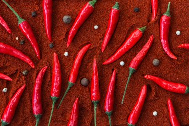 Red hot chili peppers, popüler baharatlar kavramı - güzel dağıtılmış kırmızı pul biber, kara biber ve ardıç meyveleri yuvarlak tohum kurutulmuş toz biber, kahverengi bir zemin üzerine.