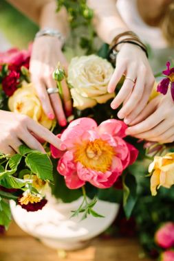buket, insanlar ve çiçek düzenleme kavramı - taze yaz sarı ve beyaz güller, pembe peonies, karanfil ve papatyalar şık buket dekorasyon iki genç kadın nazik eller üzerinde yakın çekim