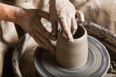 çanak çömlek, atölye, Seramik Sanat kavramı - yakın kadar erkek el parmak ve su ile yeni bazı gereçler heykeltraşlık, adam el işleri potters tekerlek ve ham şamot, üstten görünüm.